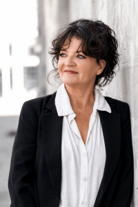 Portret van Ziggy Klazes in een zwarte blazer over een wit overhemd, met een lichte achtergrond.